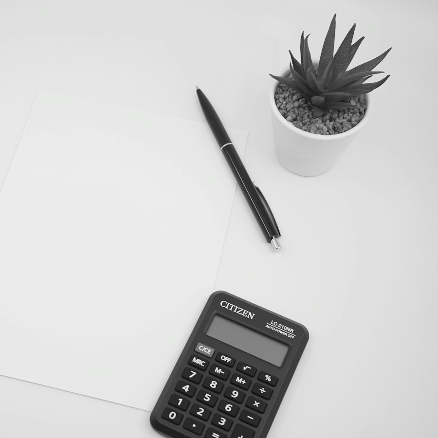 Calculadora, bolígrafo y papel en blanco sobre una mesa